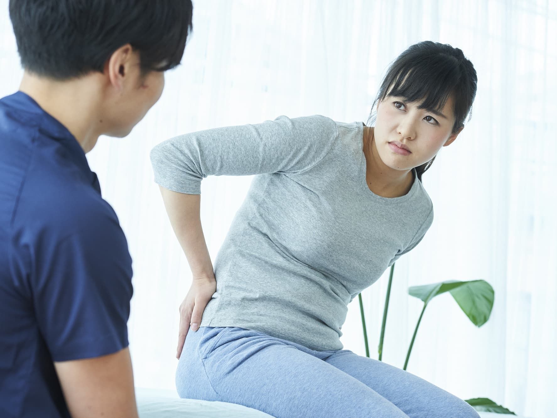 腰の痛みを訴える女性